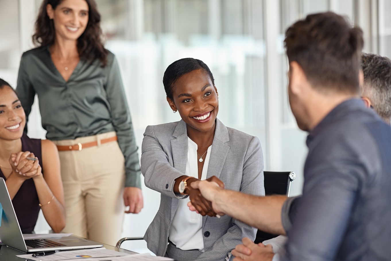 Professionals celebrating STARLIMS customer success stories and sharing a handshake.